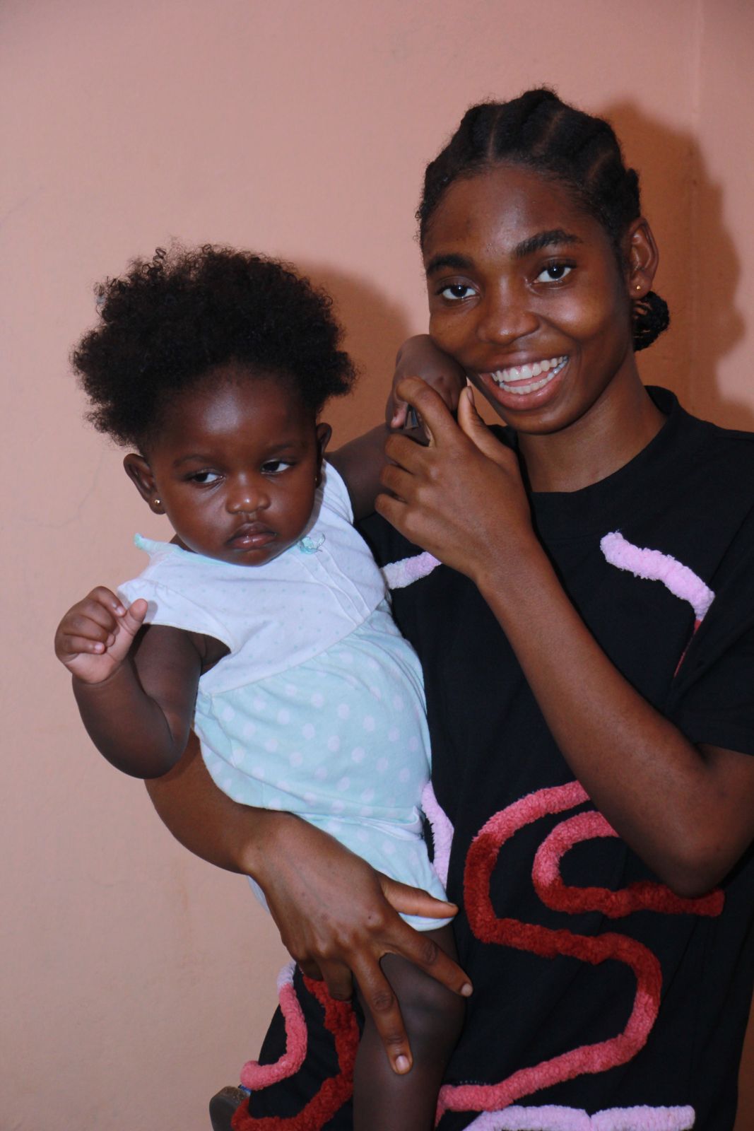 A smiling carer holding a baby