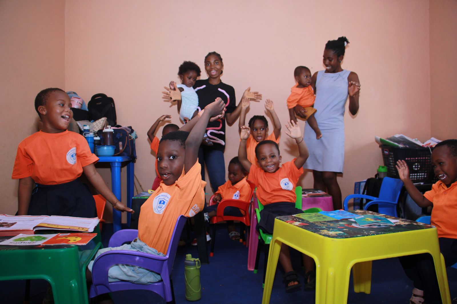 Children and teachers waving in the classroom
